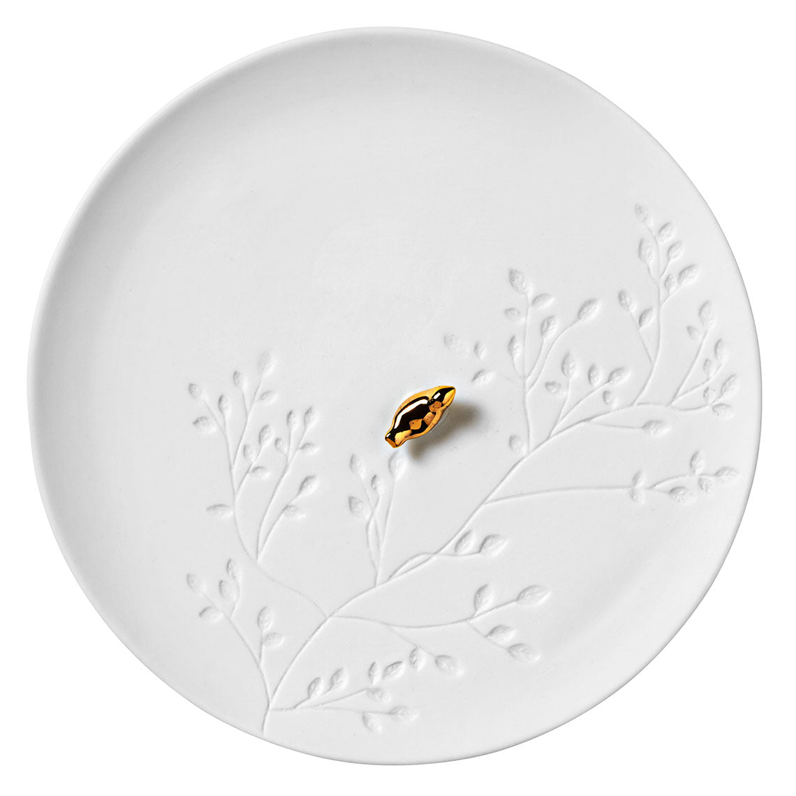 White porcelain plate with embossed design and a small black and gold object on a white background