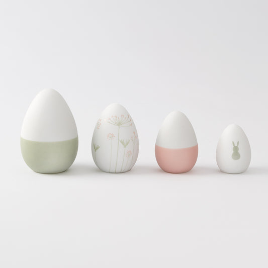 R17462 Four porcelain Easter decorative eggs with different designs on a light gray background
