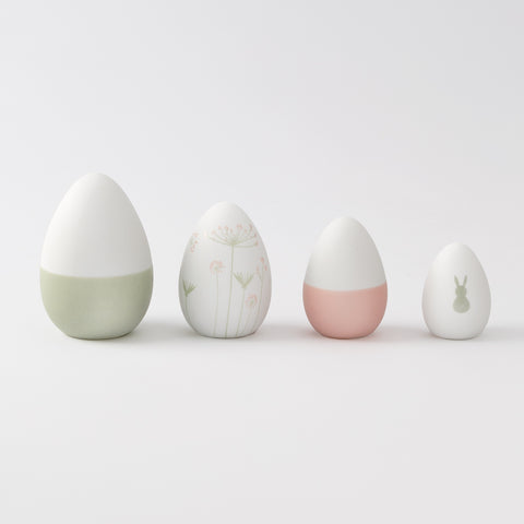 R17462 Four porcelain Easter decorative eggs with different designs on a light gray background