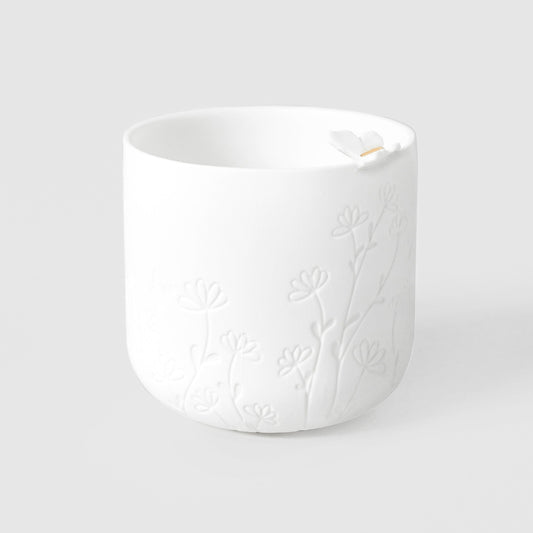 R17618 White porcelain tealight holder with floral embossing on a light gray background