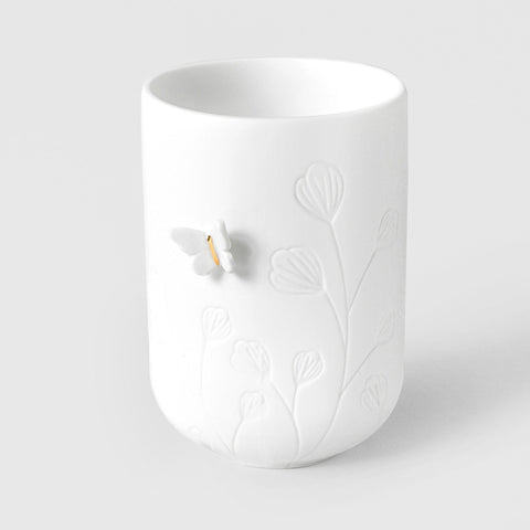 R17619 White porcelain tealight holder with embossed butterfly and floral design on a light gray background