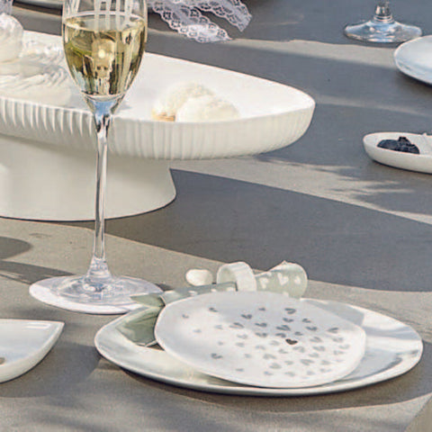 Table setting with a glass of champagne and plates on a textured surface