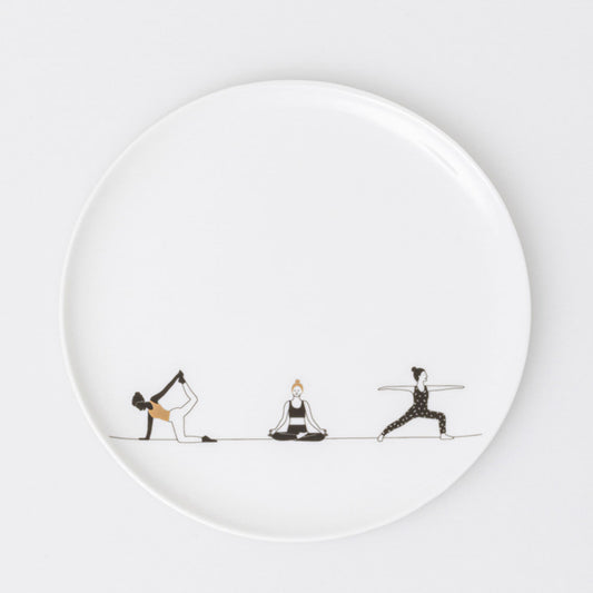 R17930 White porcelain plate with black illustrations of people doing yoga on a white background
