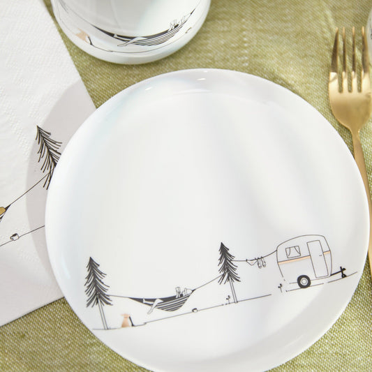 White plate with camping design on a green tablecloth