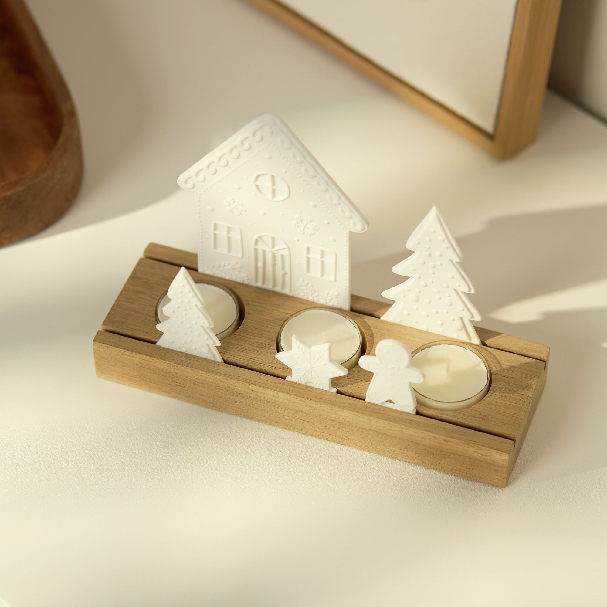 Porcelain and Acacia Wood Gingerbread themed tealight holder pictured from above is beautiful holiday decor on a white countertop.