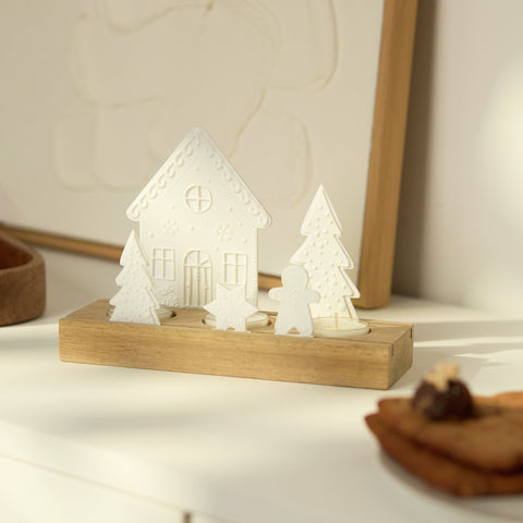 Porcelain and Acacia Wood Gingerbread themed tealight holder is beautiful holiday decor. Sitting on a counter in a home setting.