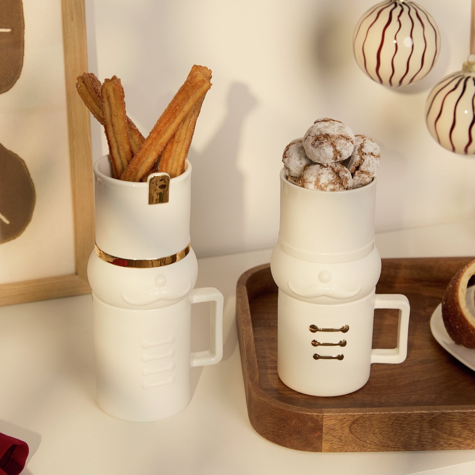 Nutcracker mug and treat sets on a counter with holiday decor around them.